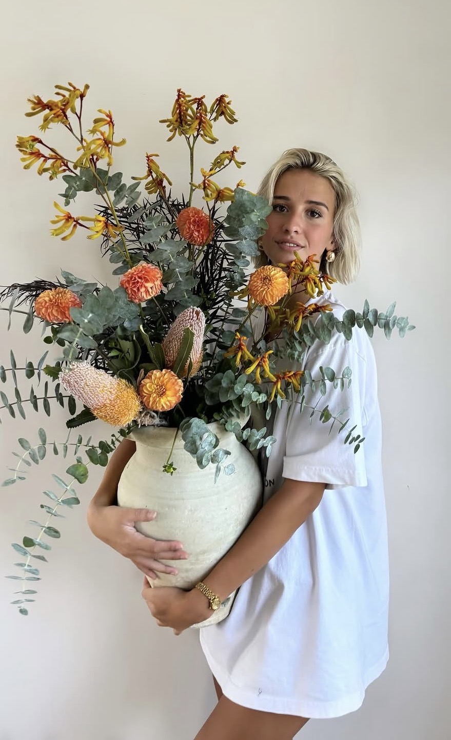 Rowan holding a stone vase of native blooms